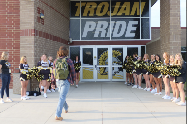 Sophomore Zephyr Mitchell walks into the AHS entryway lined by cheerleaders. Every Friday on the day of a home football game, the cheerleaders would greet those who walked into class.