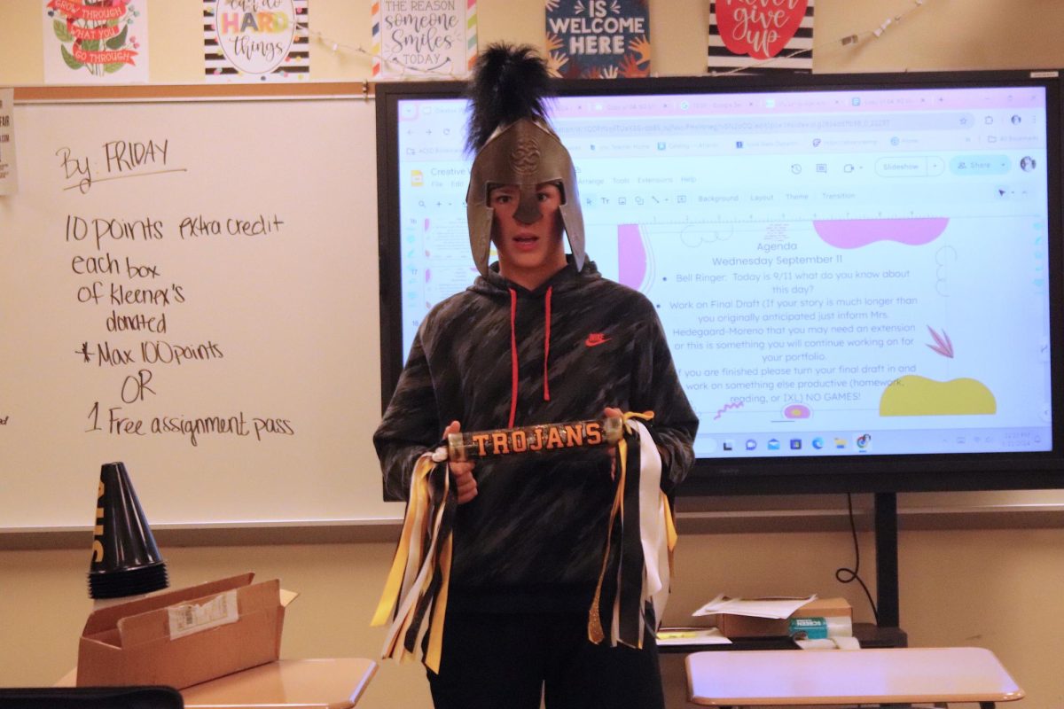 Freshman Callan Kluever poses with the Trojan Cheer Stick in Mrs. Hedegaard- Moreno's English class!