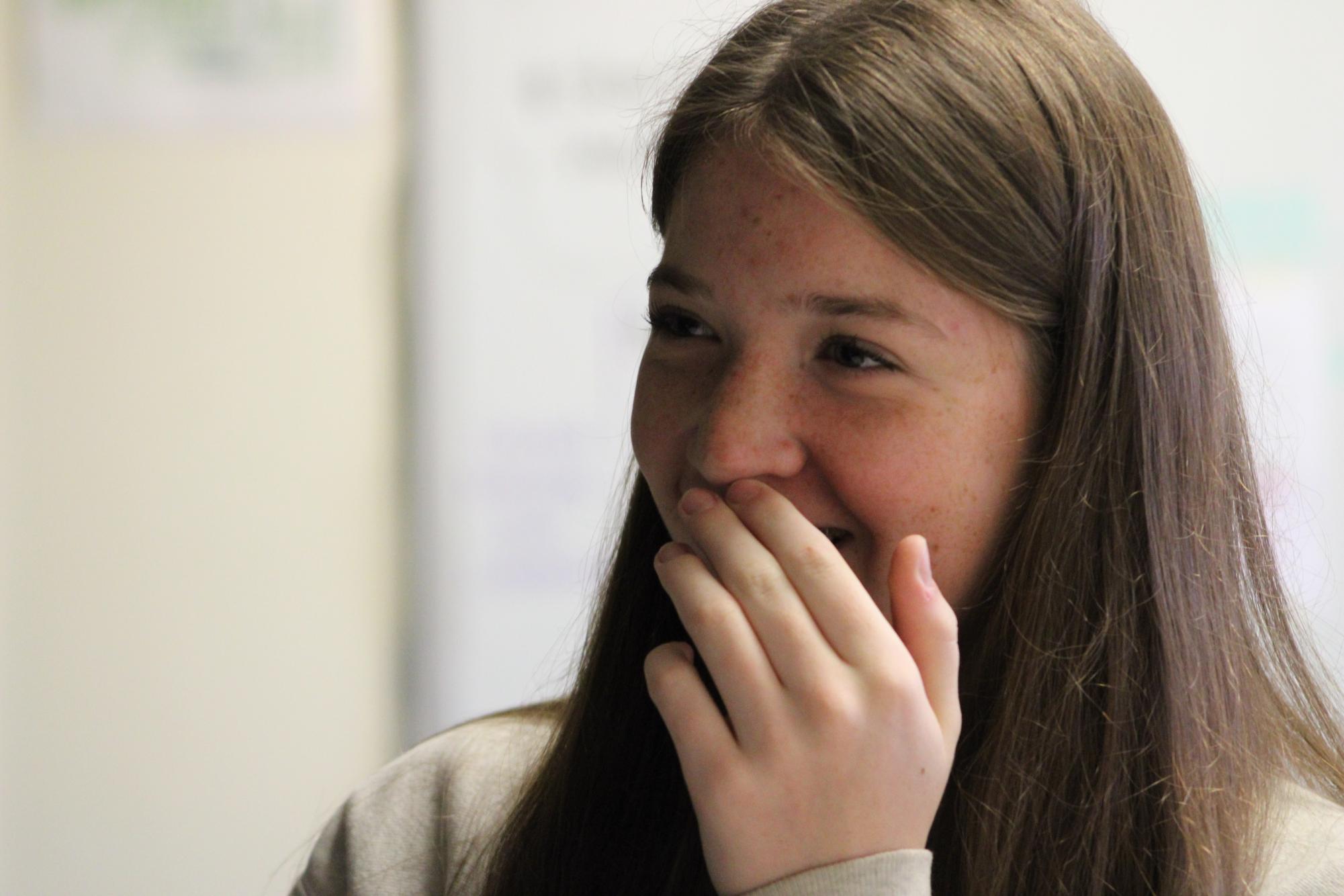 Junior Aubrey Winford laughs as she works in the Journalism lab. This is Winford's second year in the journalism program.