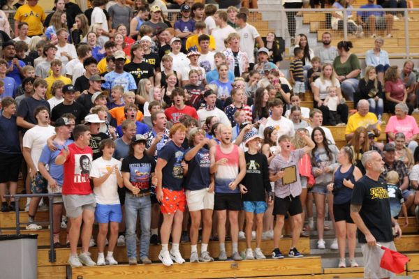 The student section cheers on the varsity volleyball team after they score the point off an intense rally. 