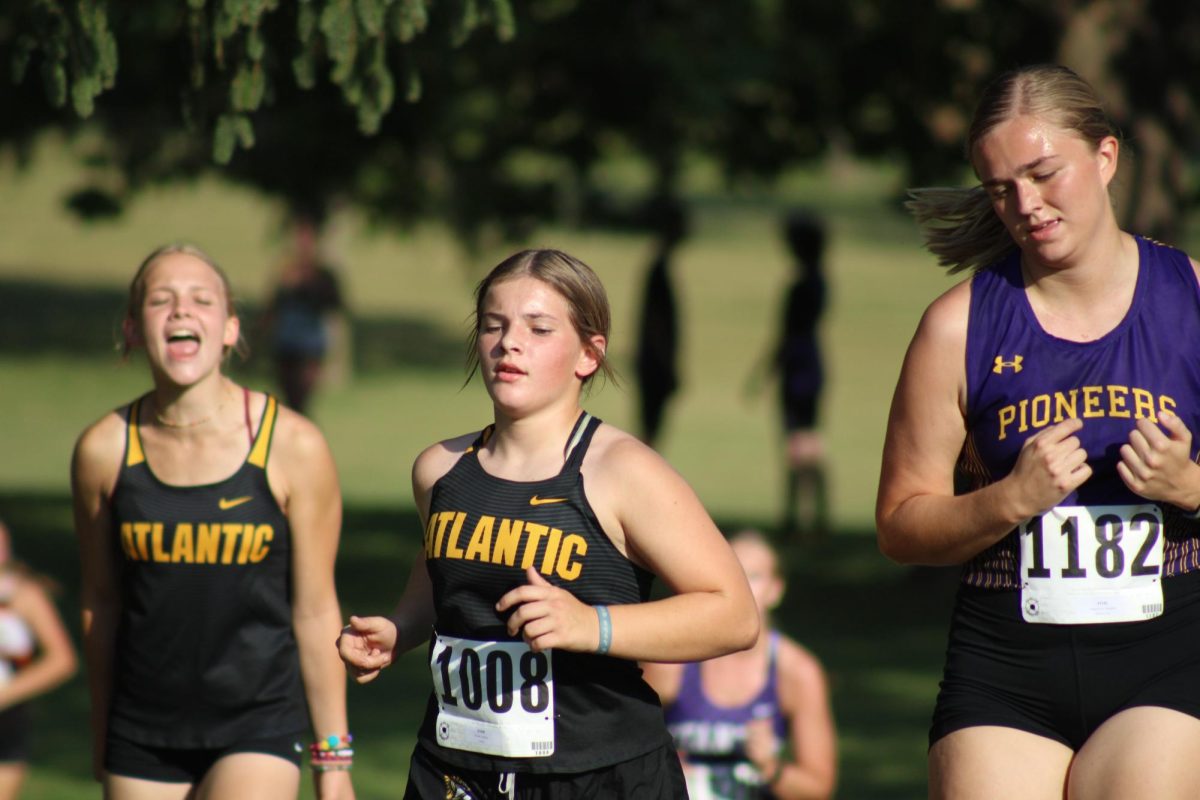 Senior Megan Birge cheers on sophomore Cadence Kinzie during her cross country meet at Clarinda.