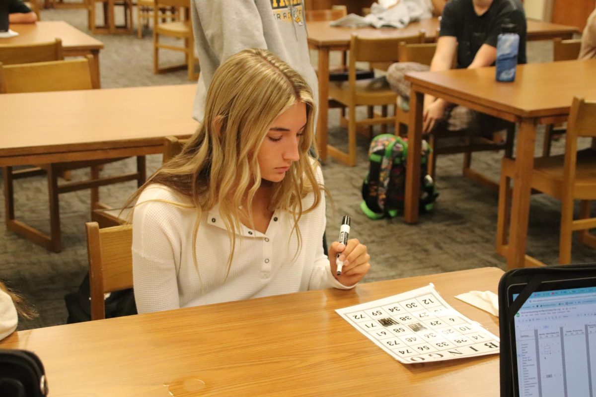 Junior Taylee Hagen marks off a spot on the bingo card for Mr. Best's seminar during Homecoming Bingo!