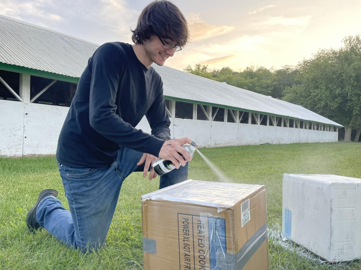 Eian Sorenson, class of 2025, spray paints props for the junior class float. (Sept. 2023) 