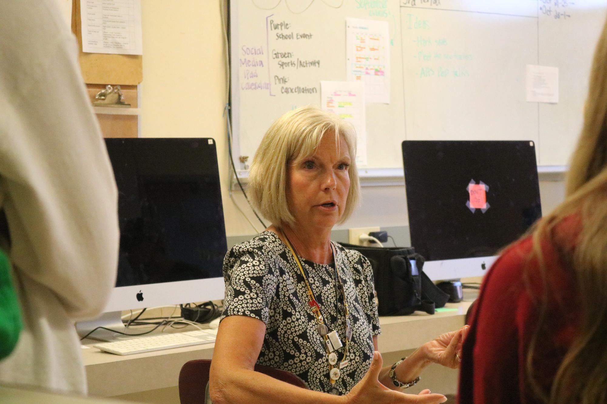 Journalism Teacher Allison Berryhill discusses upcoming events with her journalism students. The journalism department covers news over social media and other websites.