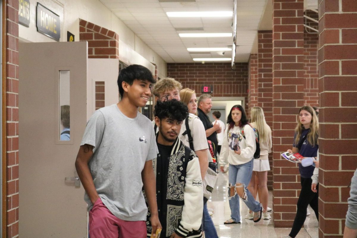 Students walk between the commons and gymnasium at the AHS College Fair. The fair was hosted on September 18 and held students from many different schools.