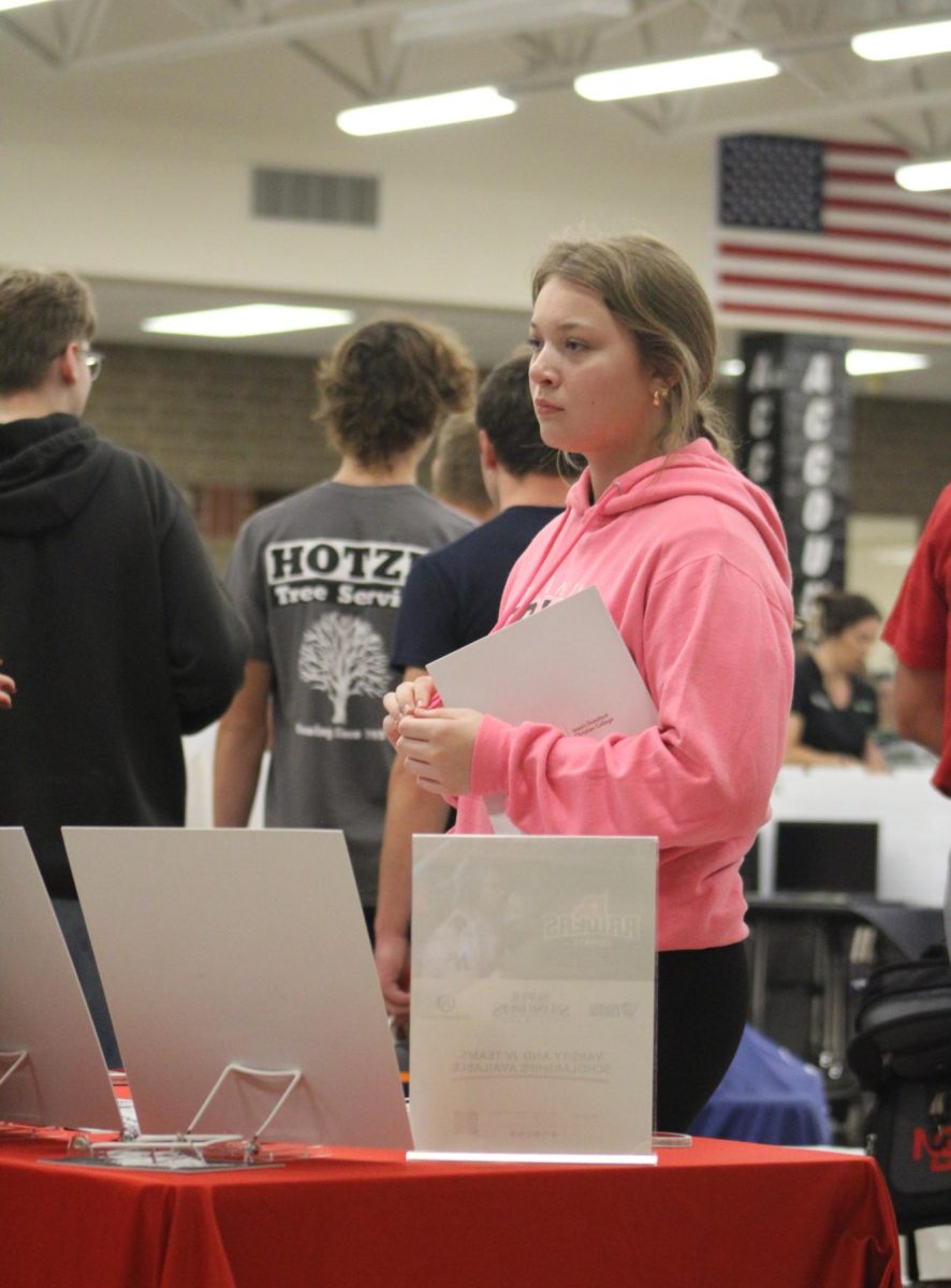 Senior Emma Winford stands at the table for Simpson College at the College Fair.