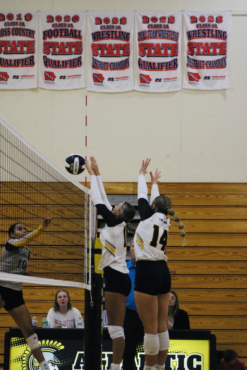 Junior Adler Bruce and sophomore Jillian Saathoff block a volleyball during the game vs. Denison.