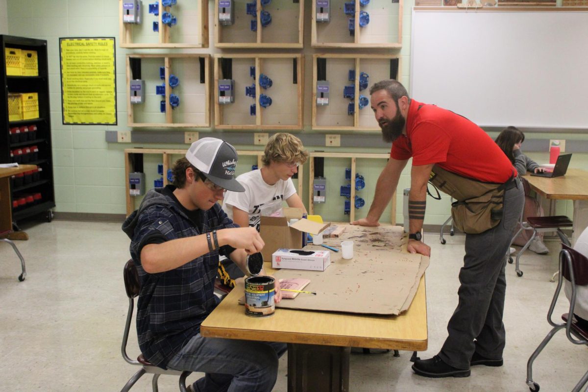 Juniors Noah Mass and Preston Williams stain their wood in Mr. Widrowicz's A.O.