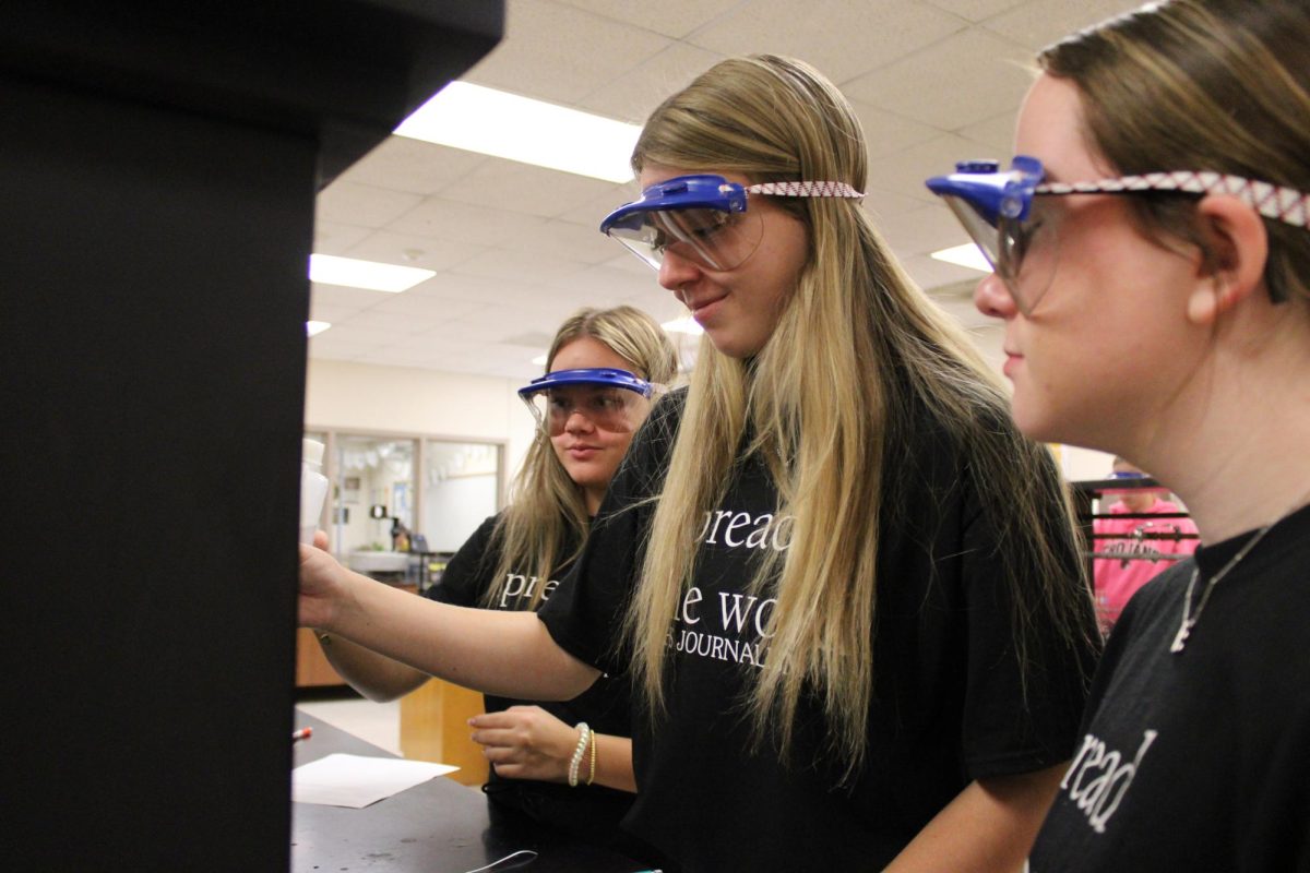 Juniors Aydrie Coffman, Aliyah Williams and Ellie Butler work on their flame lab in Ms. Misner's Chemistry class.