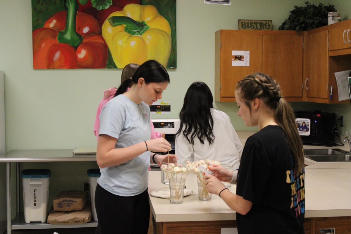 Junior Cayleigh Sarsfield and senior Mabry Ohm work together to make cake pops in their Baking and Pastry class, taught by Ms. Wallace.