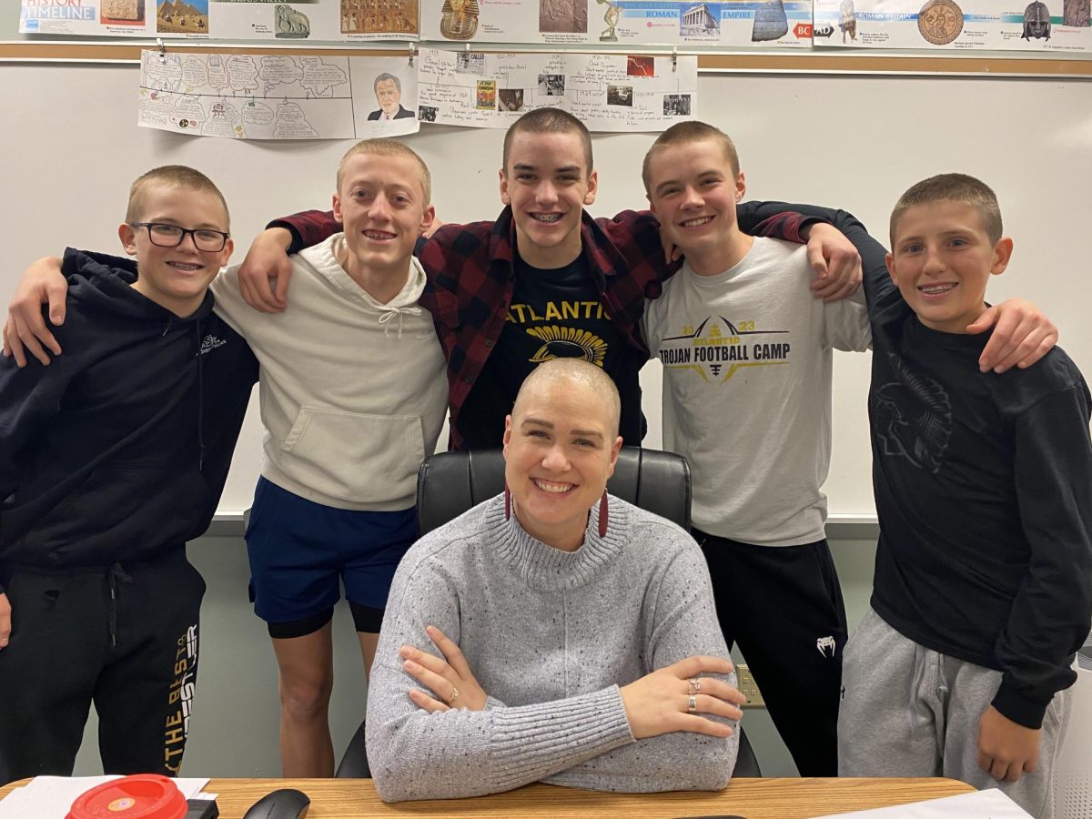 Students Colin Harris, Vincent Meisinger, Roland Hinman, Draven Mitchell, and Brandon Wagner gather around teacher Stephanie Kelley. By shaving their hair short, the boys stood in solidarity with Kelley’s cancer journey.