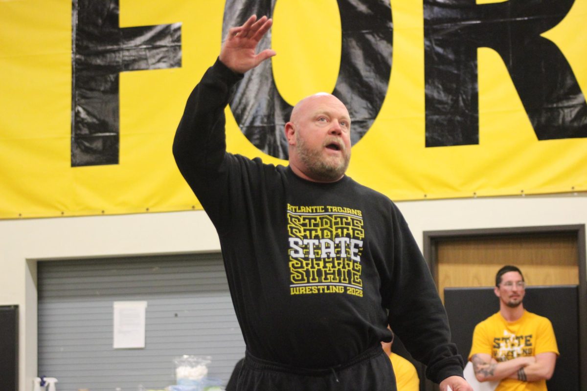 The Atlantic High School wrestling coach thanks everyone for coming out to support the wrestlers. He then explained how the rest of the night would go.