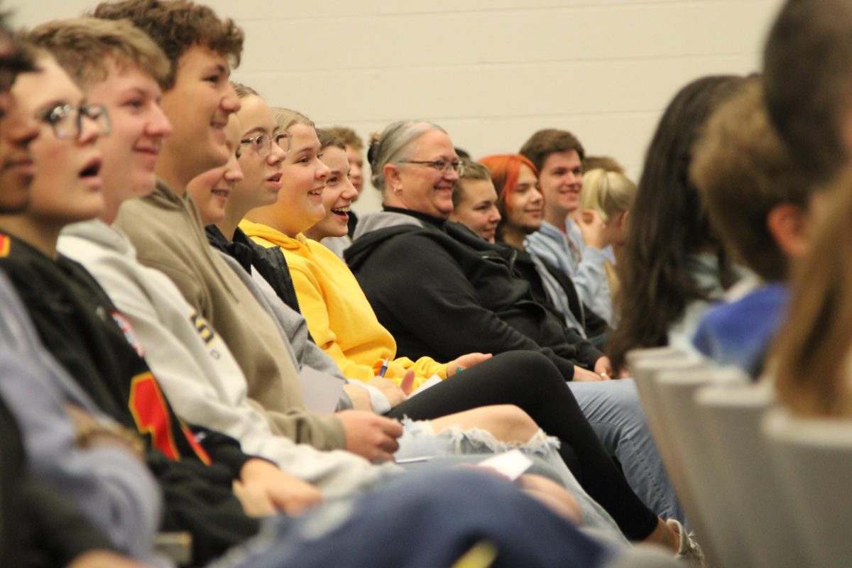 Students sitting near math teacher Sheila Hayden smile at a stunt performed by Desi Payne. Hayden offered her phone to Payne for the stunt. "It wasn't my phone. It was Payne's. She gave it to me before the show." said Hayden. Payne and Hayden together fooled the whole school.