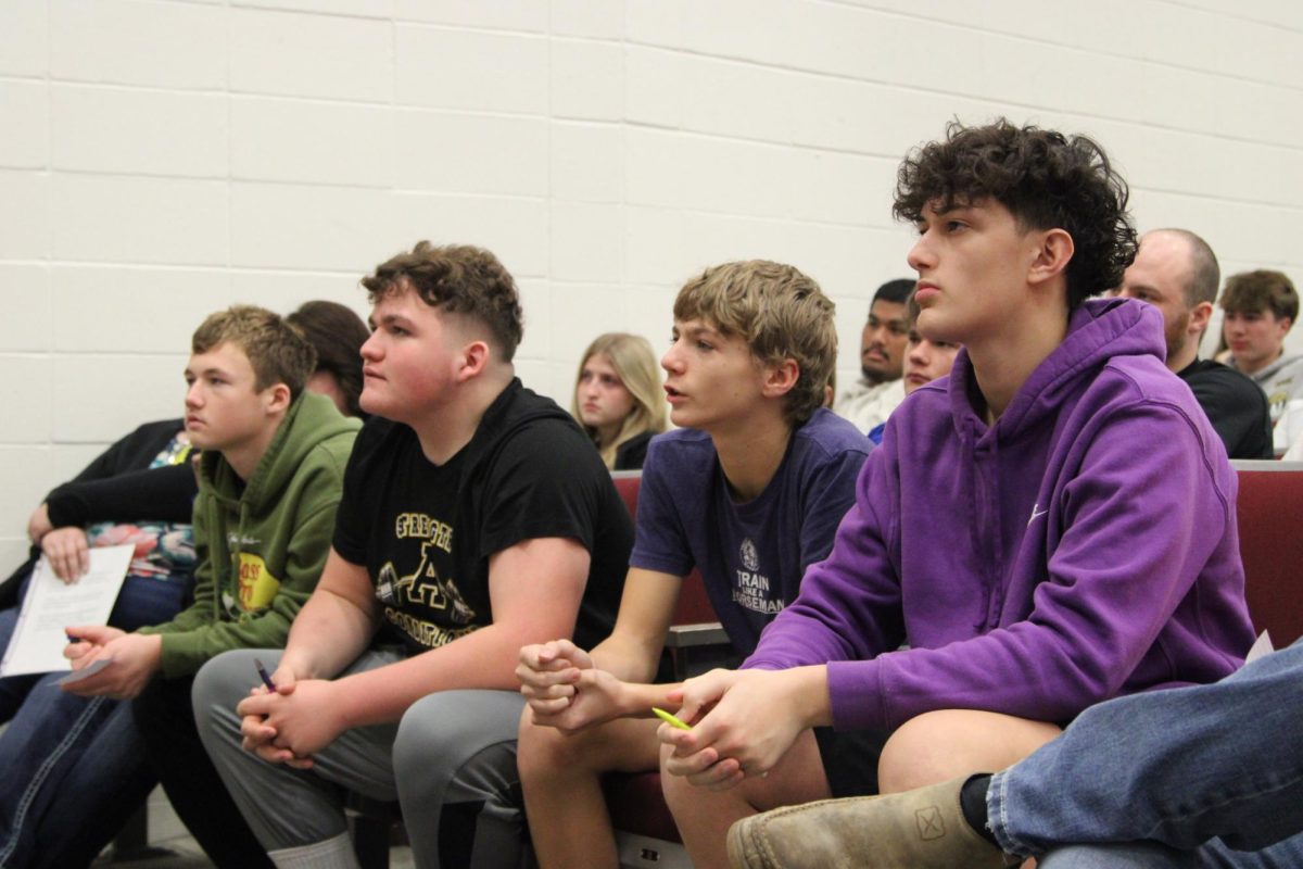 Ryan Gunderson, Travin Thomas, Mason Betts, and Nicolas McBride listen to the speaker. McBride was "enjoying the messages that Payne was sending." He remembered the magic tricks as "captivating."