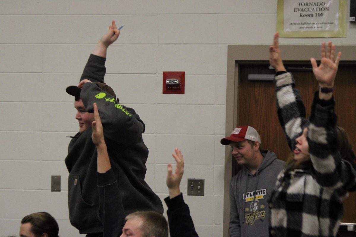 Jace McIntyre jumps in the air to be seen by Payne. Payne was looking for a volunteer to lead the school in the "Y.M.C.A." McIntyre was chosen and led the dance along with several other students. 