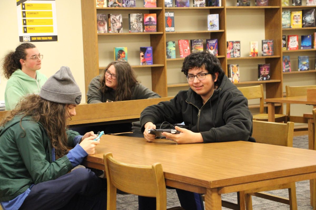 TIME TO SWITCH - Aden Brockwell and Charlie Ortiz continue gaming on their handheld consoles as Tessa Cox and Lucas Houston discuss in the background. Game Club is an event where people can meet to share their love for games. Some sort out into small groups while others are content to game independently in an environment that welcomes it.