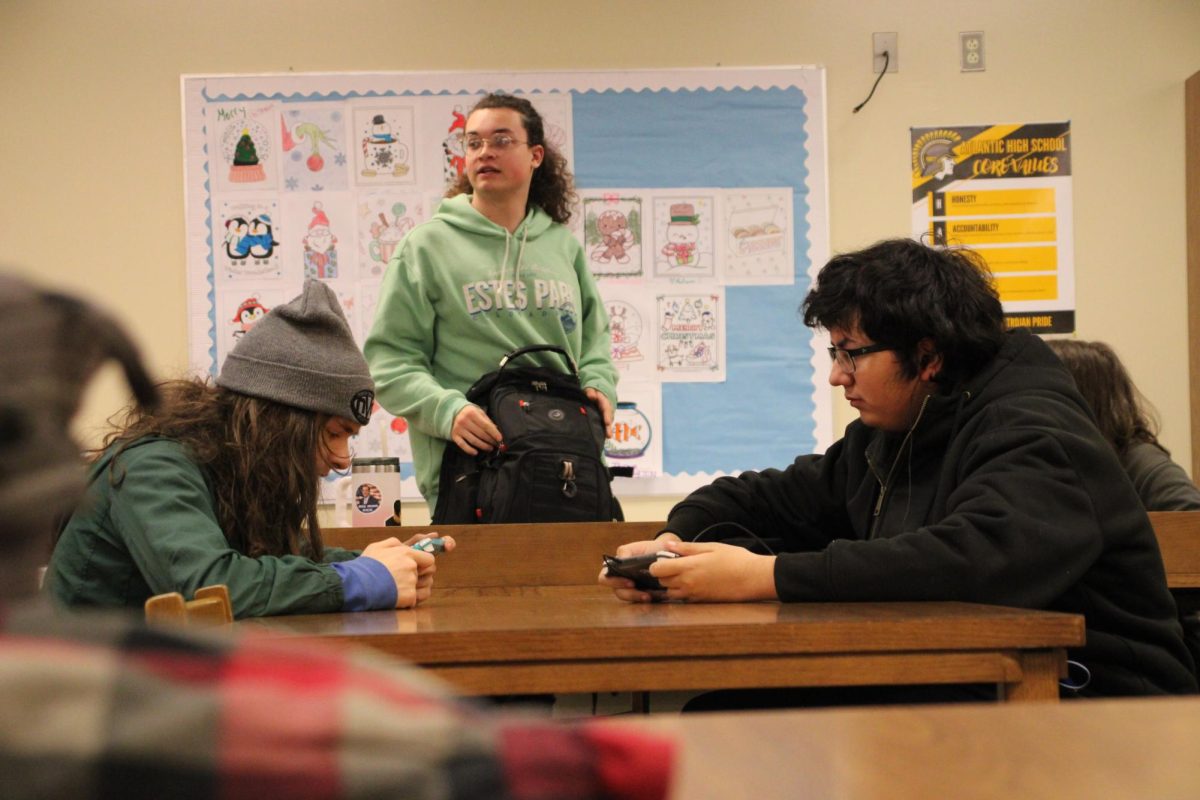 GAME ON! - 
Aden Brockwell and Charlie Ortiz play games on their Nintendo Switch Lights while Tessa (Caden) Cox sets her bag down. Brockwell and Ortiz discussed the popular franchise Pokémon, particularly Pokémon Legends: Arceus, during their sesh. Pokémon is a frequent topic of discussion during Game Club, and competitive tournaments are held from time to time involving the Pokémon Trading Card Game.