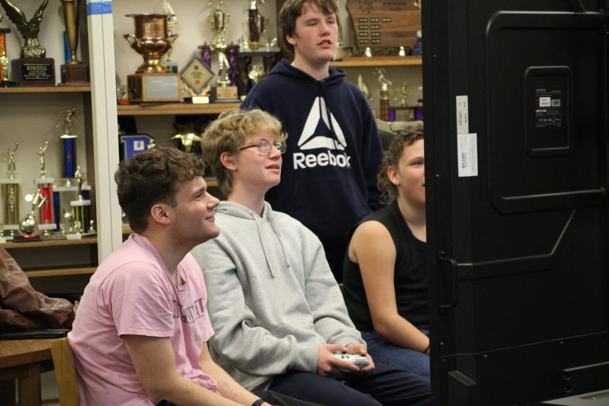 THE PRESSURE'S ON - Noah Huddleson and Landon Larson group up to watch Logan Olson and Wiatt Green play a first-person shooter game. The game's intensity had them leaning forward in their seats, eyes trained on the screen. Each trivial slip-up and high-stakes moment earned a groan of disappointment or an encouraging comment from the surrounding group.