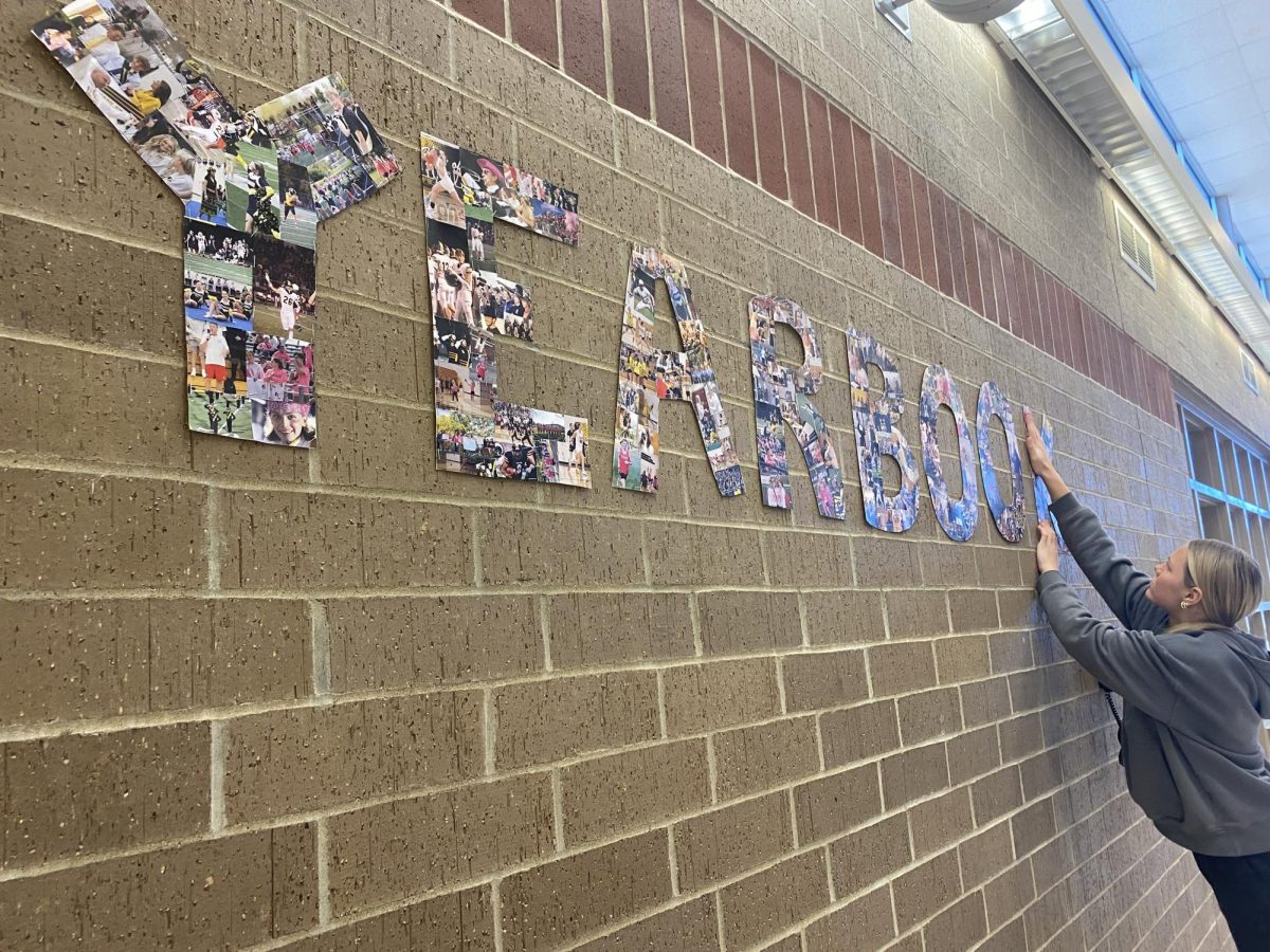 Junior Lila Wiederstein displays a photo collage spelling "YEARBOOK".