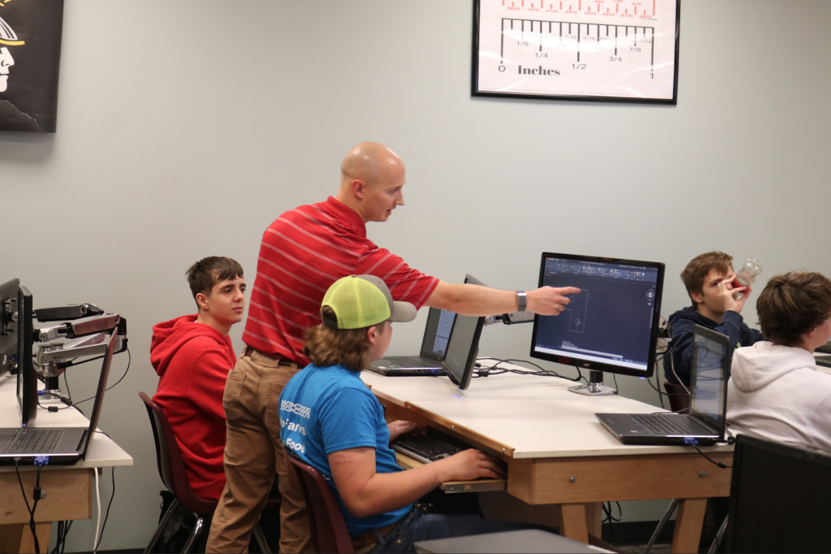 Mr. Dodson explains to students Allan King and Grant Christensen what to do on their assignment. He provided them with the help they needed. They got the project done.
