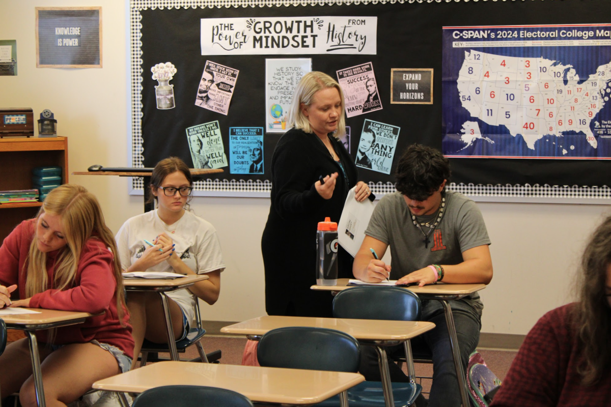 Teacher Holly Esbeck looks over Keelin Rasmussen's packet. In her class students filled out a packet. Rasmussen had a question on a page and Esbeck helped him.