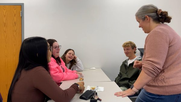 Several dual-enrolled high school students talk with professor Diana Blake.