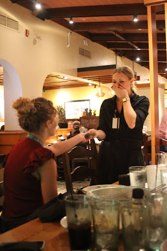 Senior officer Lola Comes hands a lucky waitress one thousand dollars in a cash tip during National FFA Convention dinner. 