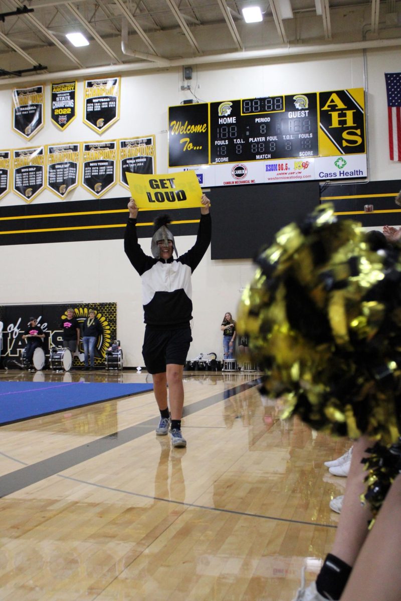 GET LOUD-- Trojan Mascot runs down the student body bleachers conducting a crowd wave. 