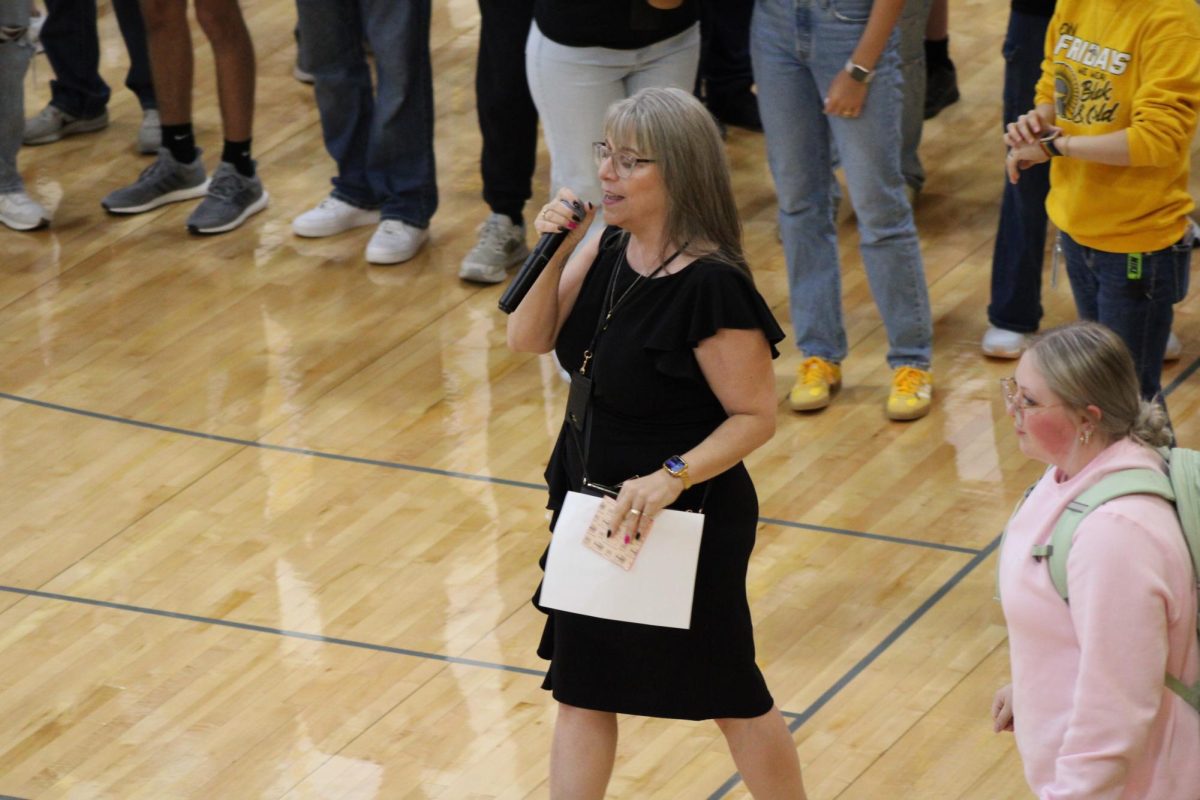 ROCK, PAPER, SCISSORS, SHOOT!-- Principal Heather McKay talking to the Trojan student body at the opening day seminar assmebly.