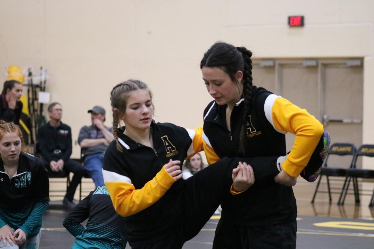 WARM-UP BUDDIES!- Sophomore Cadence Kinzie and junior Lily Johnson warm up together. Before their matches the girls practiced their skills. They helped each other improve their tactics. 