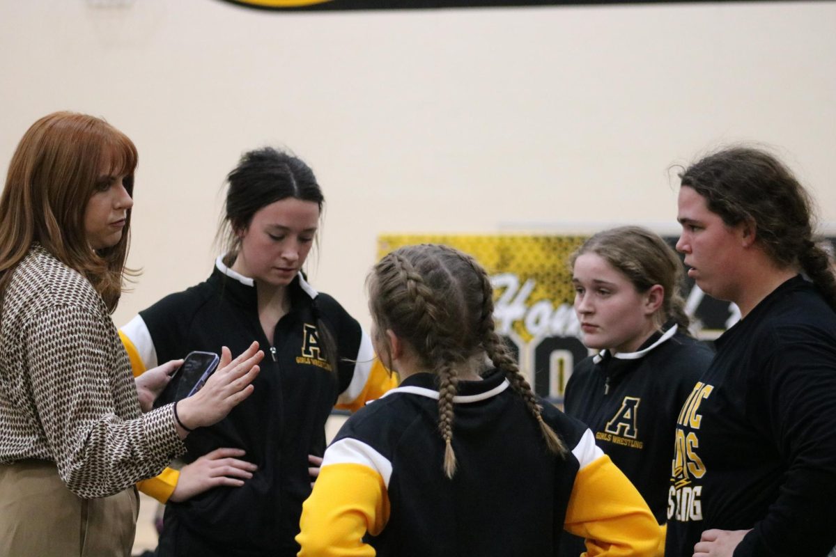 PEP TALK- Assistant coach Lillian Cox gives the girls a pep talk before their matches. Cox helped knock the nerves out of the girls. This was their first home meet.