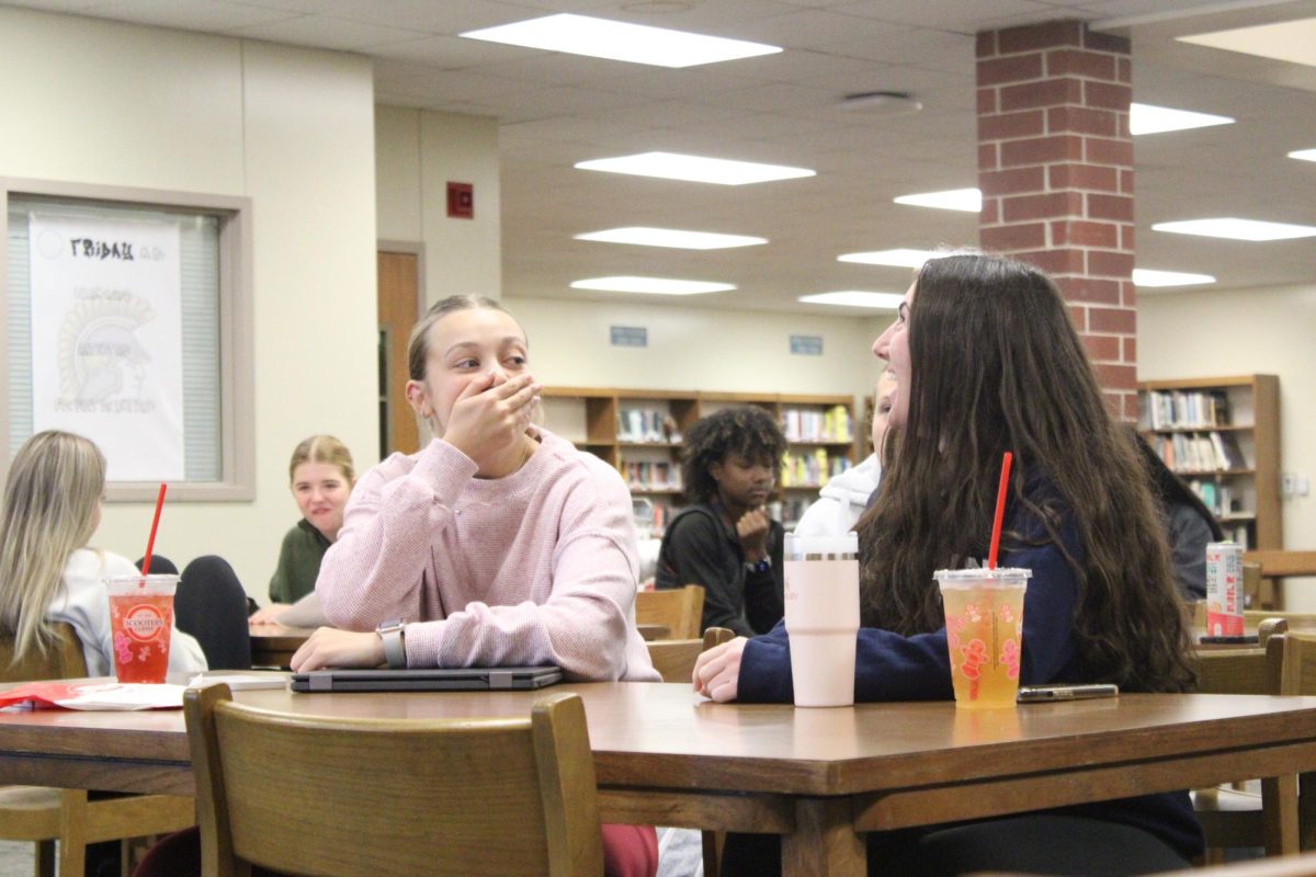 Jayci Reed and Morgan Botos sit and laugh together and discuss Student Council Activities. 