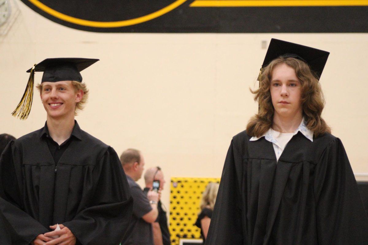 Kinnick Juhl and Henry Knudson walk down to their spots moments before graduating. Emotions ranged from smiling to seious. Graduation was held in the AHS gym on May 18. 