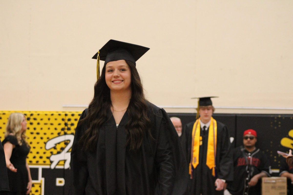 Senior Kylie Templeton smiles on her way down the aisle before becoming a graduate. Templeton was a part of many things such as journalism, football managing, and dancing at Villa Dance Company. Templeton plans to become a phlebotomy technician. 