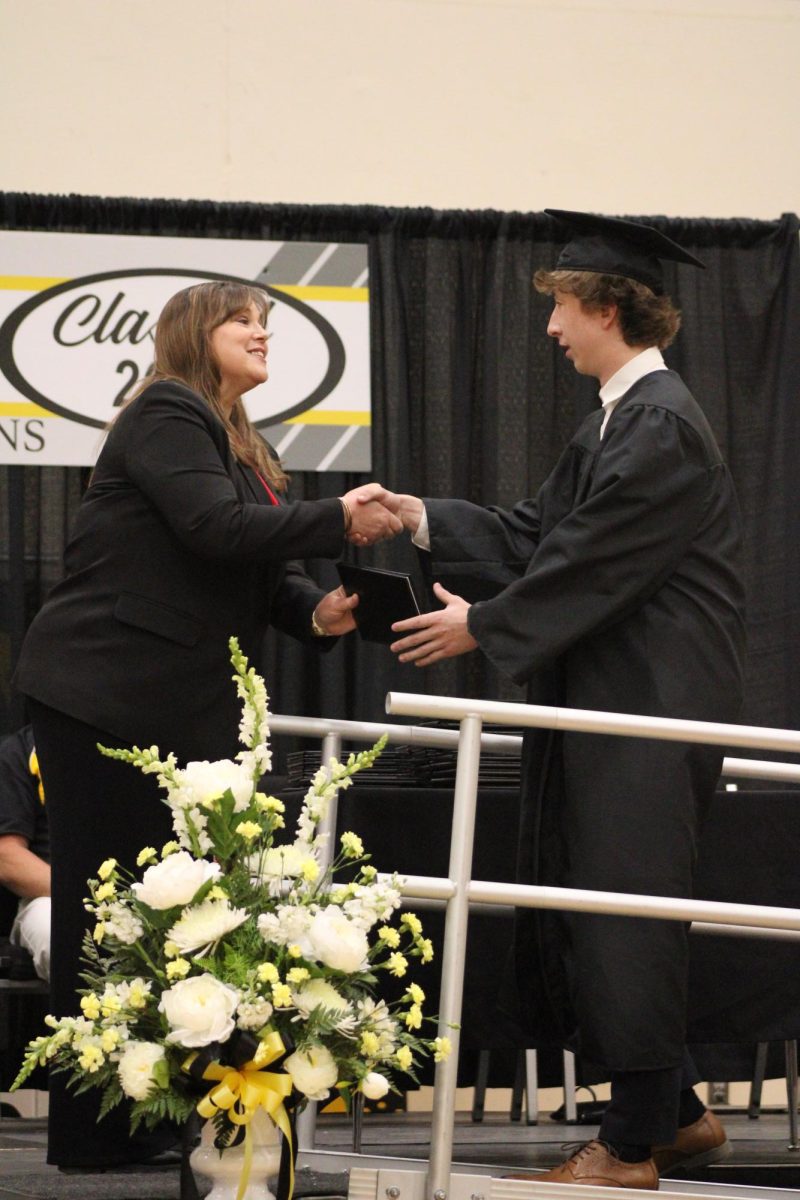 Conner Silence shakes Laura McLean's hand before grabbing his diploma. 