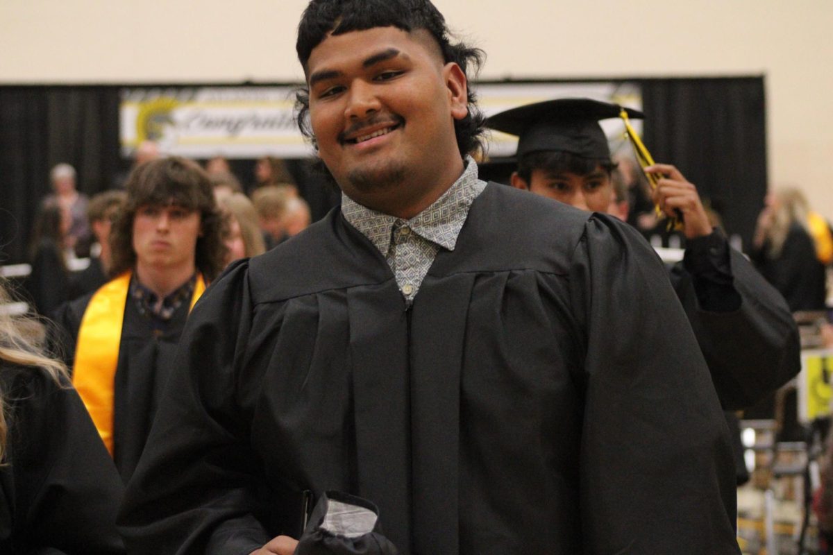 Reed Flaisek smiles big while walking out of the gym after finally graduating. 