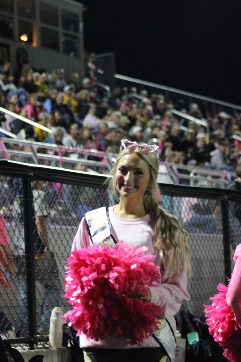 Senior Madelyn Anderson cheers at her last home football game. She said she's so excited to cheer during the playoff game. She has participated in cheer for three years and has loved the experience each year. 