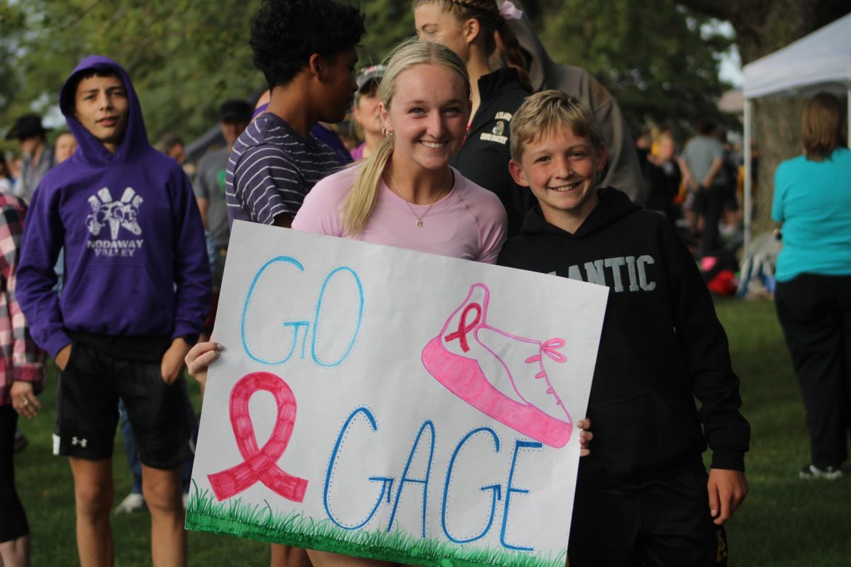Makenna Schroeder cheers on her brother Gage as he runs at the pink out cross country meet. He's in eighth grade and can't wait to compete in high school. 