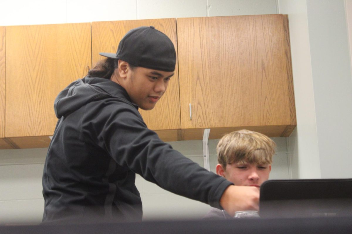 Sophomore AK Hartman helps Landon Hemminger with his work for math class.
