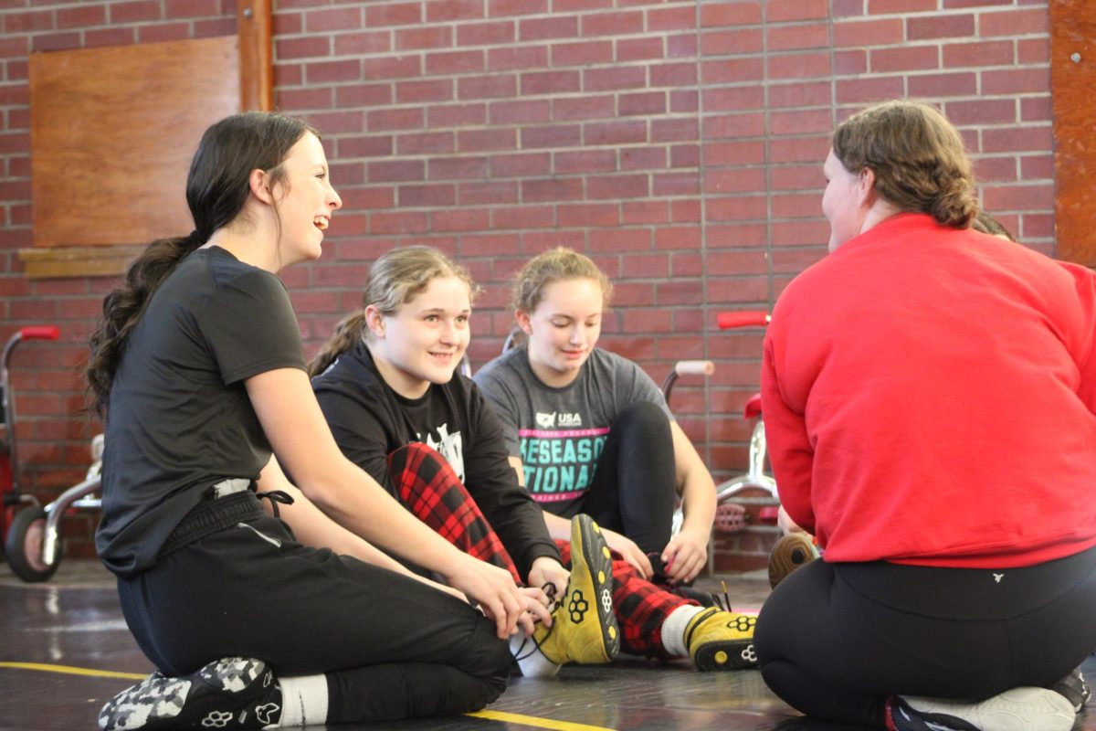 Sophomore Leiah Thomas and Senior Lily Johnson listened to Assistant Coach Lexie as she was telling stories.