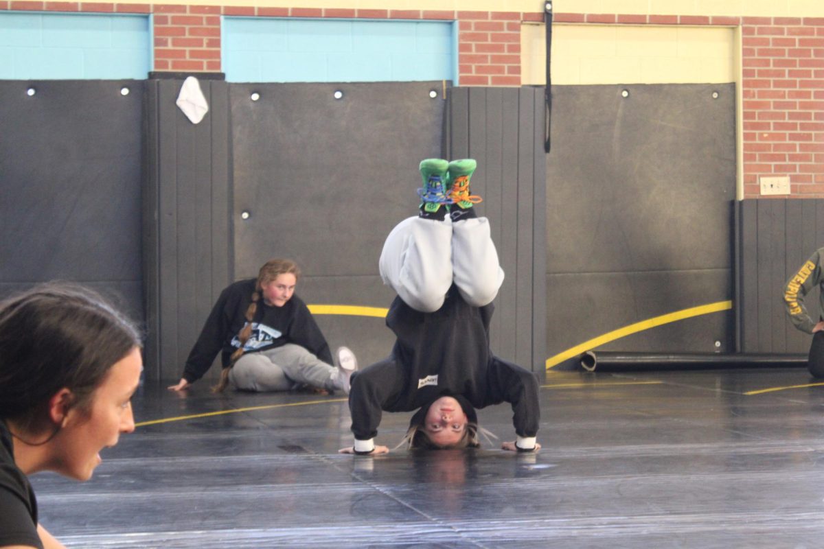 Cadence Kinzie balances in a headstand during practice. She held herself steady as the team continued their warm-up.