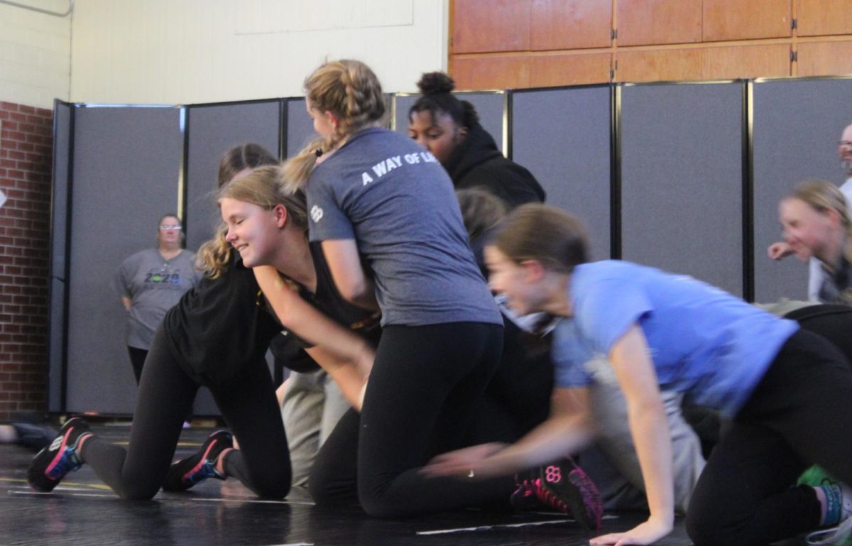 Freshman Josie Miller works to break free while the group crowds around her in a practice game. She was determined as she wrestled her way toward open space. 