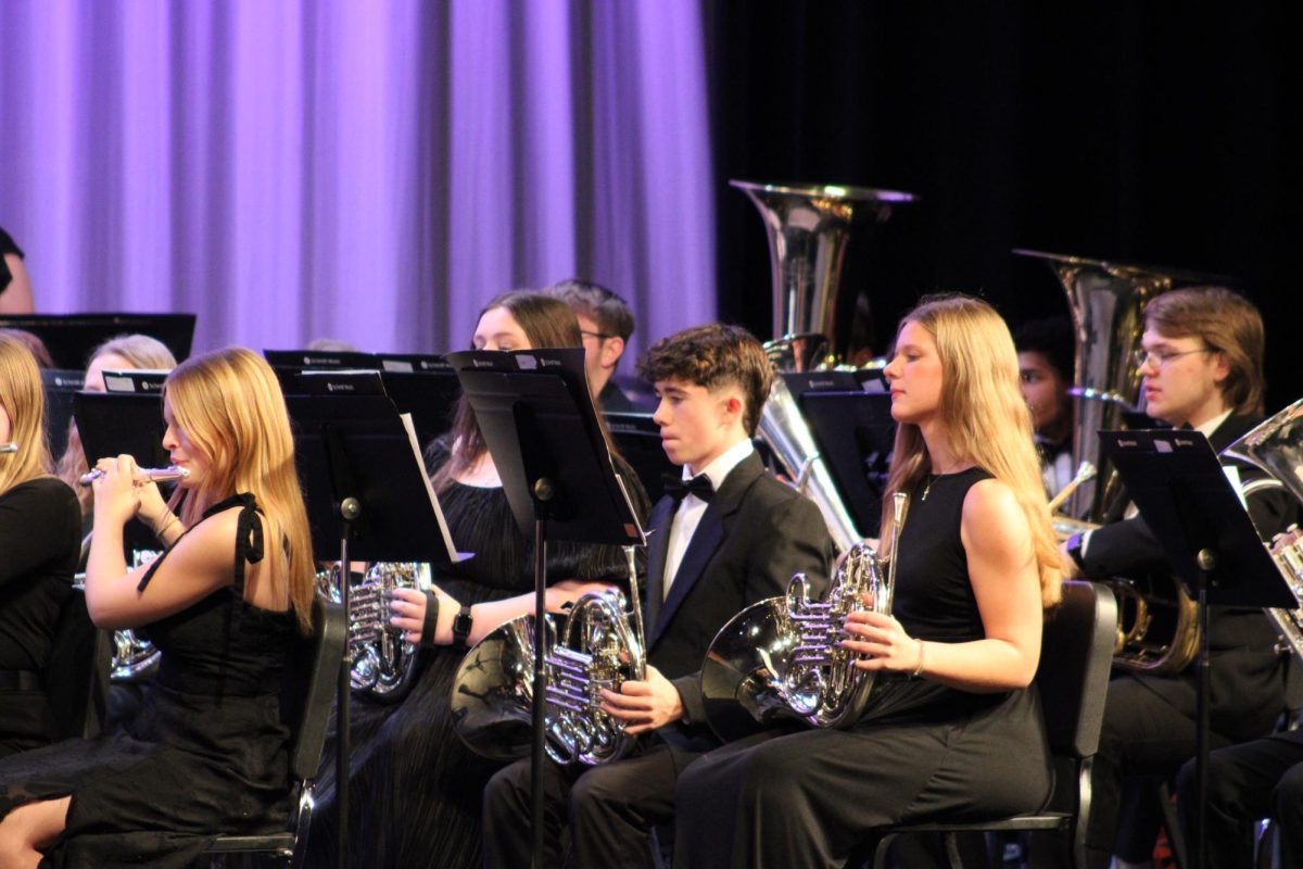 The brass section is tuning up as they wait for their cue. Hours of practice paid off from their performance at the concert. 