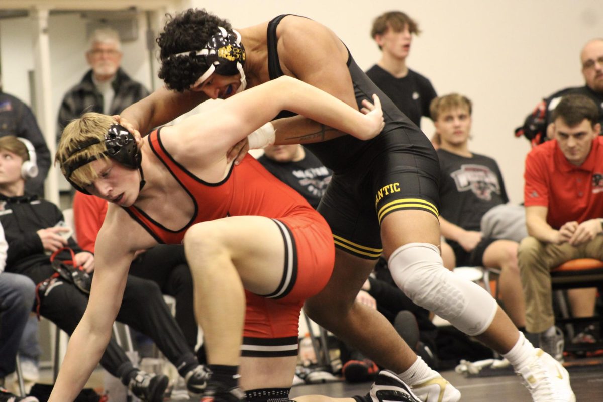 Senior Donovan Hedrington on the move to keep his opponent down. The intensity of the competition is evident. Hedrington's skill is on display as he strives for victory.