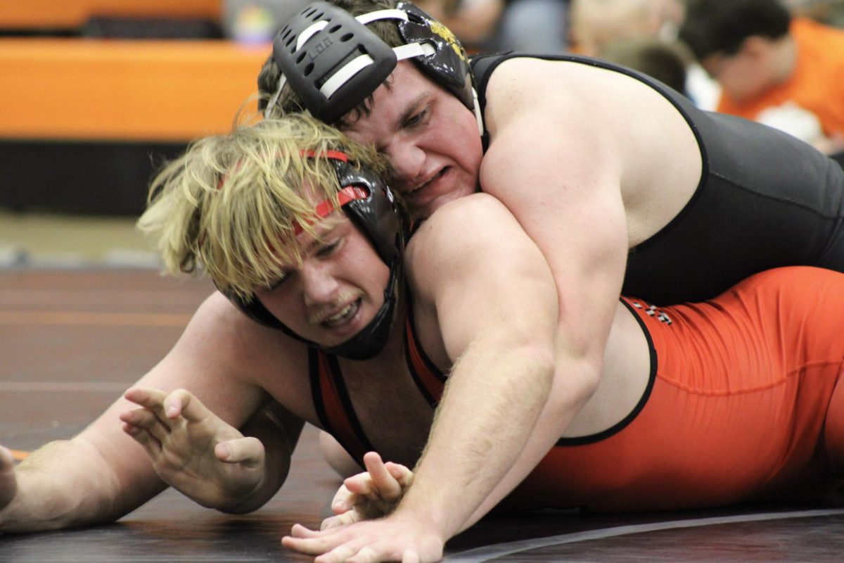 Sophomore Travin Thomas keeping his opponent down.Thomas grapples with his opponent, putting all his strength on the mat.Thomas's determination won him the match with his whole team cheering him on.