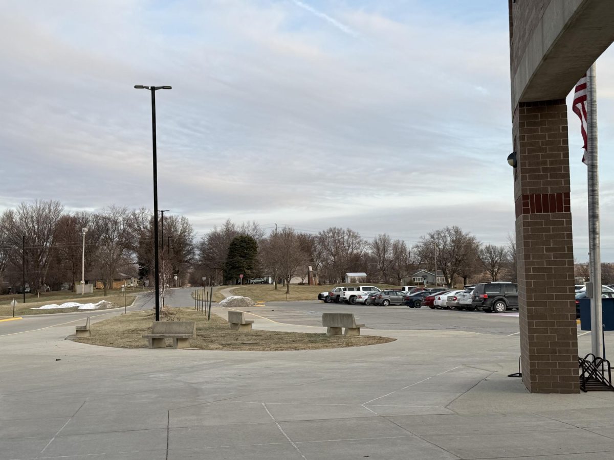 The school parking lot during the winter  with a few piles of snow from the snow storm that happened a few weeks ago. 