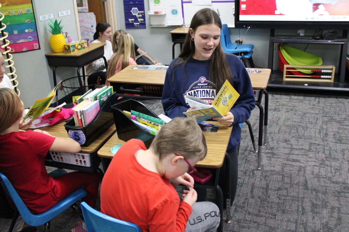 Freshman Reese Harlan is reading to him little partner from Washington elementary.While Reese Olsen was reading to him,her partner was laughing and sneezing at a funny joke from the book.