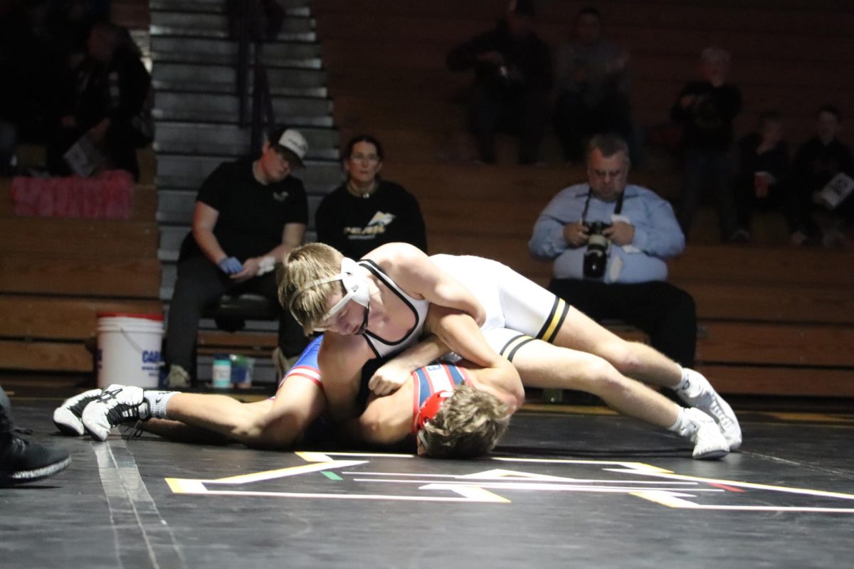 Keaton Schroeder is holding down his opponent. He is earning back points but not pinning him because both shoulders are not toughing. Schroeder wins the match after this move.