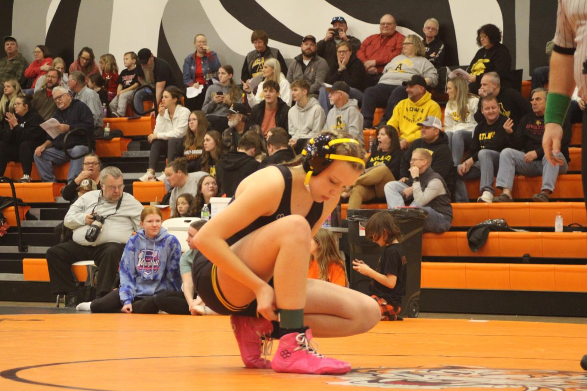 Willow Drake kneels down to put a band on her ankle. She finished adjusting it before the match. Ready to compete.