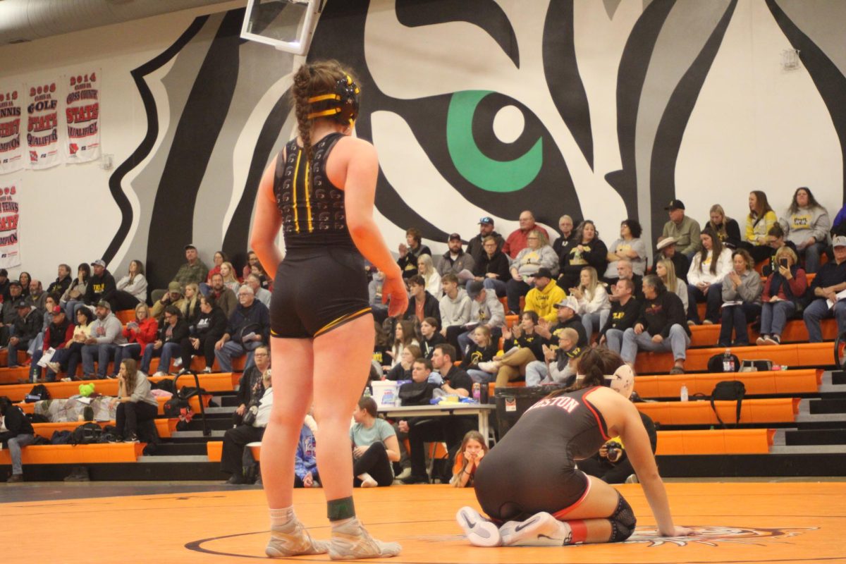 Alivia Knuth stands up while staying ready on the mat. She was on top and waited for the referee to give the signal. The moment showed discipline and control.
